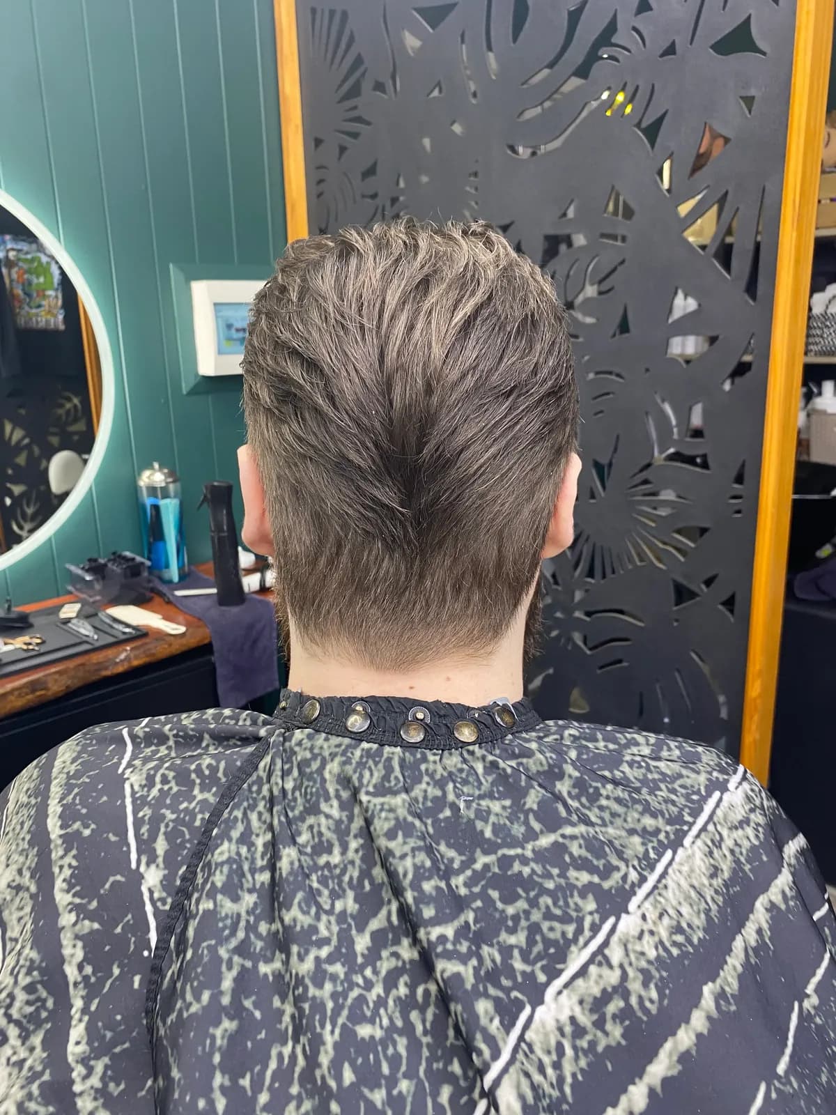Back view of a tapered haircut with a V-shaped neckline at Bear Cave Barbershop