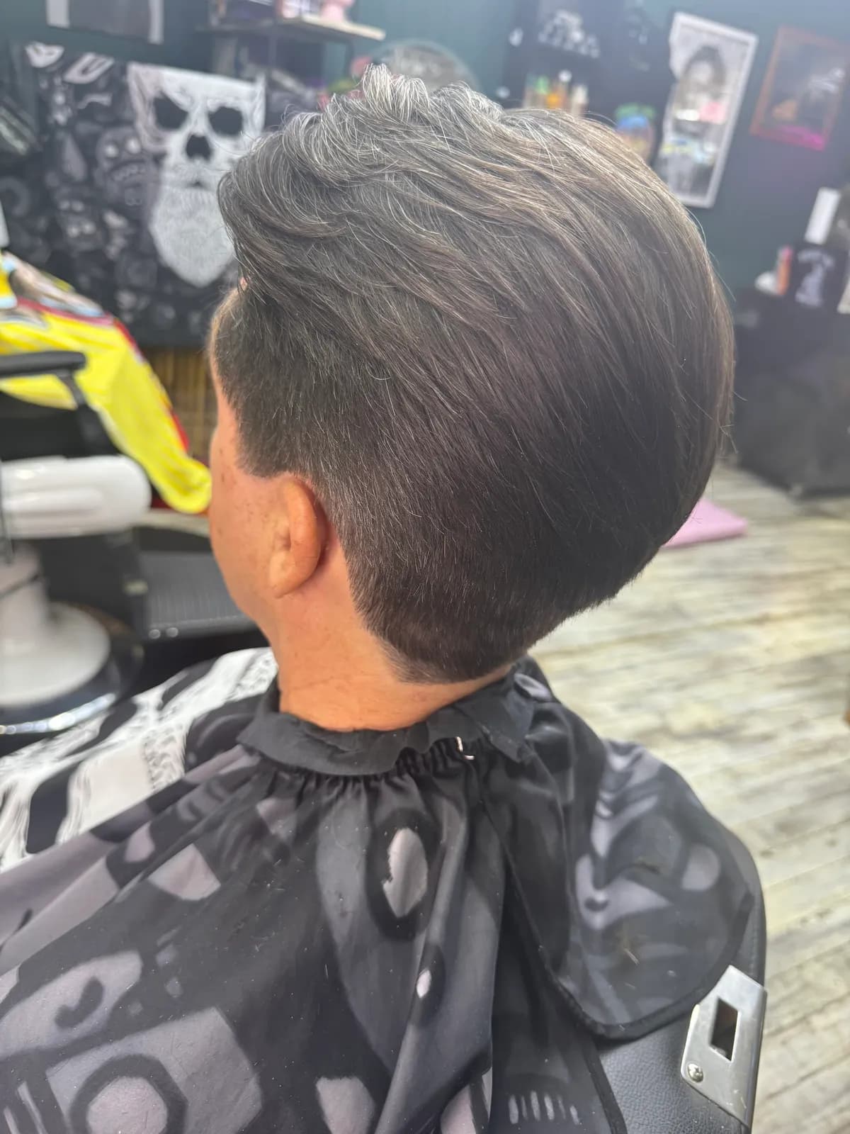 Back view of a graduated haircut with silver-grey tones at Bear Cave Barbershop